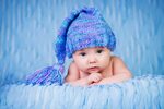 A baby child in a beautiful knitted blue hat Desktop wallpap